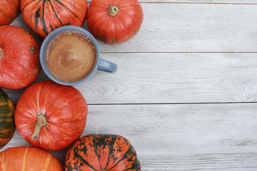 Grey cup and orange pumpkins on white wooden table. Autumn drink, pumpkin latte concept. Fall, hot drink, thanksgiving, top view, copy space