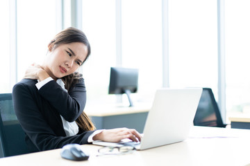 Asian businesswoman in office hard working.  Office syndrome and workaholic in office people concept.  Hard working businesswoman in office having a health problem.