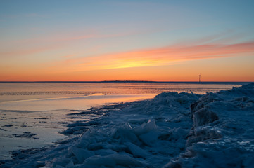 Icy sea with drift ice piling on the shore