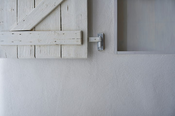 Empty shelf in white wall with wooden shabby white shutter