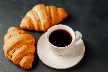 coffee and croissants on a stone background, morning breakfast