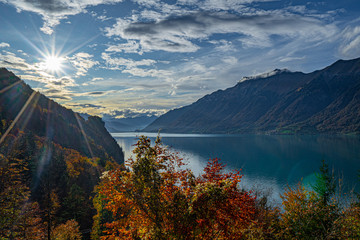 Brienzersee im Herbst vom Giessbach Grand Hotel tiefliegende Sonne Wolken blauer Himmel farbige Bäume Abendstimmung