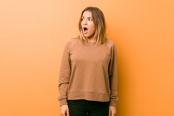 Young authentic charismatic real people woman against a wall being shocked because of something she has seen.