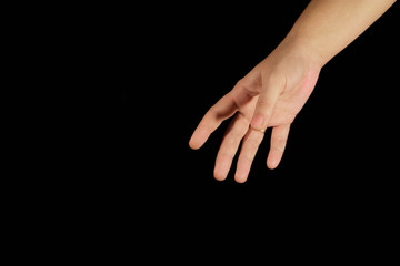 A woman's hand reaches out from a top corner. Isolated women open palms on a black background. Concept of helping hand, relations, help, kindness, choice and support. Hands close-up and copy space.