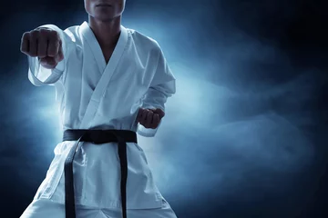 Gordijnen Karate martial arts fighter on dark background © fotokitas