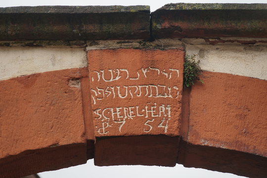 Historischer Schlussstein mit hebräischer Inschrift an einem Torbogen