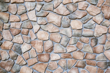 Gray concrete surface with uneven cracked stones. Grunge rocks decorative interior wall texture.