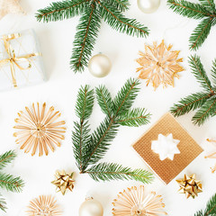 Christmas / New Year holiday composition. Fir branches, gift boxes, Christmas baubles, straw decorations on white background. Flat lay, top view festive concept.