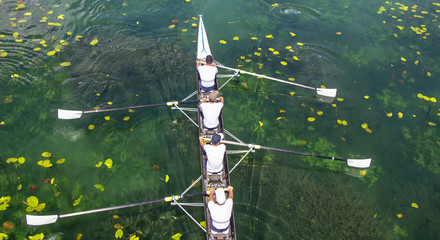 Men's quadruple rowing team on turquoise green lake - 300392815