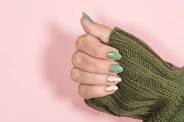 Closeup top view of beautiful two faded colors trendy manicure of  green, pink nails with glossy...