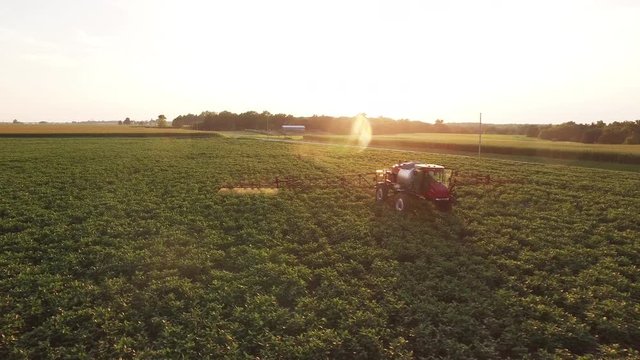 Sunset over tractor in Illinois, wide aerial
