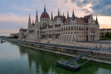 Fototapeta premium Aerial view of the beautiful Hungarian Parliament building by River Danube on a bright summer day with blue sky and clouds