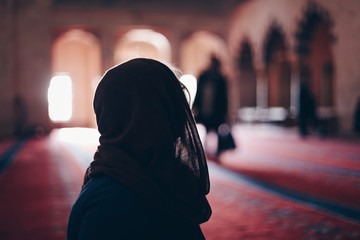 portrait of a beautiful blonde tourist woman visiting kocatepe mosque in ankara, turkey. concept of travelling and experiencing new religions and cultures