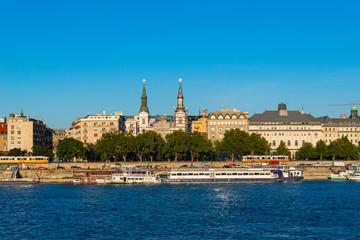 Fototapeta na wymiar Budapest, Hungary - October 01, 2019: Cityscape of Budapest with Orthodox Cathedral of Our Lady with passenger boats on the Danube river, Budapest, Hungary.