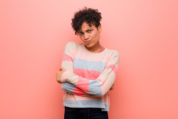 Young mixed african american teenager woman frowning face in displeasure, keeps arms folded.