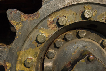 Fragment of tank wheel with exfoliated paint and rivets