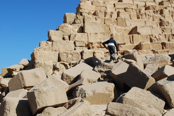 Mann kletet auf eine Pyramide