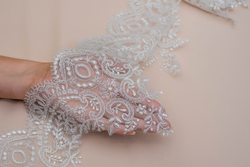 Texture lace fabric. lace on white background studio. thin fabric made of yarn or thread. a background image of ivory-colored lace cloth. White lace on beige background.