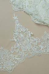 Texture lace fabric. lace on white background studio. thin fabric made of yarn or thread. a background image of ivory-colored lace cloth. White lace on beige background.