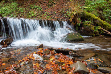 Fototapeta na wymiar Colorful majestic waterfall in autumn forest