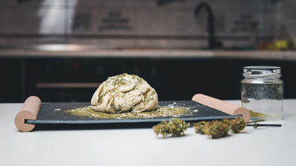 Preparing to cooking hemp cake or bread. Close-up of fresh dough with cannabis flour.