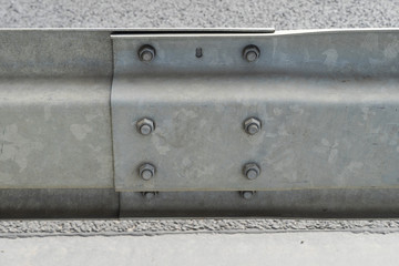 Galvanized or metal road barriers, close-up. Fence connection with metal bolts.