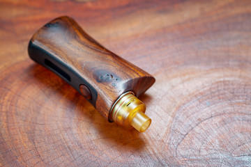 high end rebuildable dripping atomizer with natural stabilized wood regulated box mods on natural...