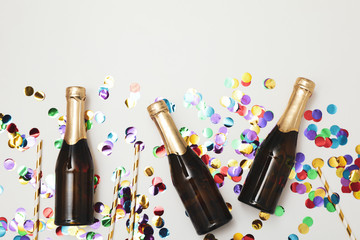 Composition with mini champagne bottles and glitter on white background, copy space © Atlas