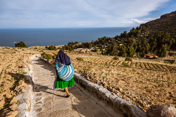 AMANTANI ISLAND, PUNO, PERU:  Woman with traditional dress down the hike on Amantani Island