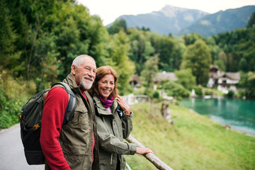 Fototapeta na wymiar A senior pensioner couple hiking in nature, resting. Copy space.