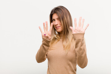 young pretty woman smiling and looking friendly, showing number nine or ninth with hand forward,...
