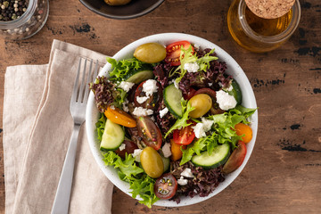 Fresh healthy salad on wooden table. Top View with copy space.