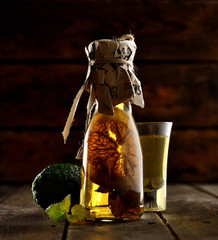 Limoncello in a bottle on a wooden background.Tradtitional italian homemade lemon beverage.