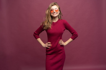 Portrait of a casual happy woman standing isolated over pink background.