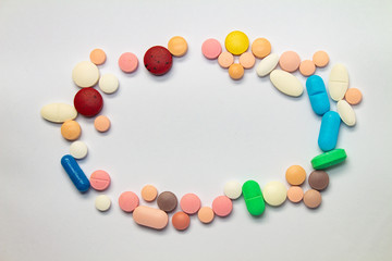 Colored pills forming a circle on white background. Concept of medication abuse. Drugs for legal use