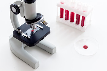 Blood testing laboratory. Samples viewing under microscope near tubes on white background top view