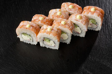 Sushi Rolls with cucumber, shrimp, crab meat and Cream Cheese inside on black slate isolated. Philadelphia roll sushi with shrimp. Sushi menu. Horizontal photo.