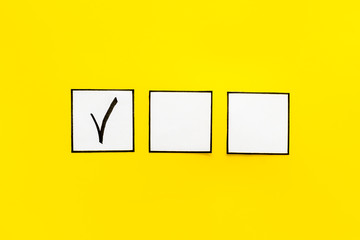 Check mark in check-box on yellow background top view copy space