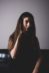 A serious young woman sitting on a sofa