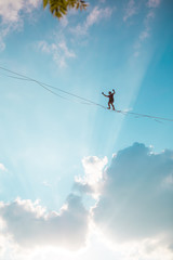 Highliner on the background of blue sky.