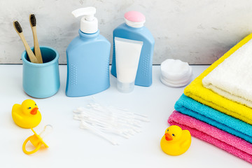 Cute bathroom cosmetics set with yellow rubber duck on white background