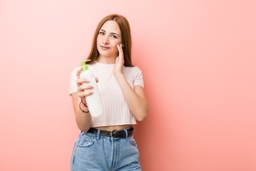 Young caucasian woman holding a cream bottle