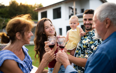 Portrait of people with wine outdoors on family garden barbecue.
