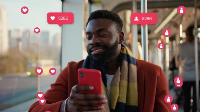 NEW YORK - April 5, 2019: African American Young Businessman Use Phone in Tram. Vlogger Influencer. Animation with User Interface - Likes, Followers, Comments for Social Media from Smartphone