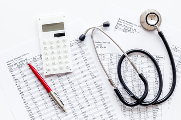 Health insurance concept. Stethoscope near financial documents and calculator on white background top view