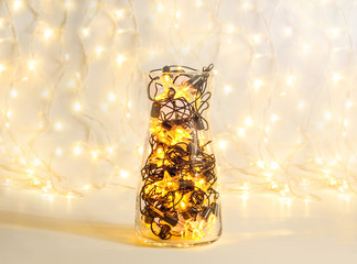 Christmas garland with star shape lamps in a glass transparent vase, holiday festive decor
