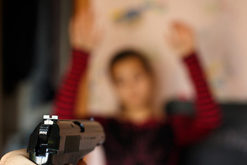 A criminal threatens a young girl with a gun