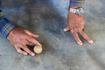 Close-up top shoot of old man plays traditional turkish game on concrete