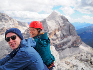 Obraz na płótnie Canvas portrait of mountain climber couple in their twenties enjoying a break on the top of a mountain