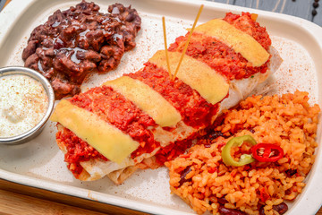 greek gyro wrap cut in half and served with fries on wooden background